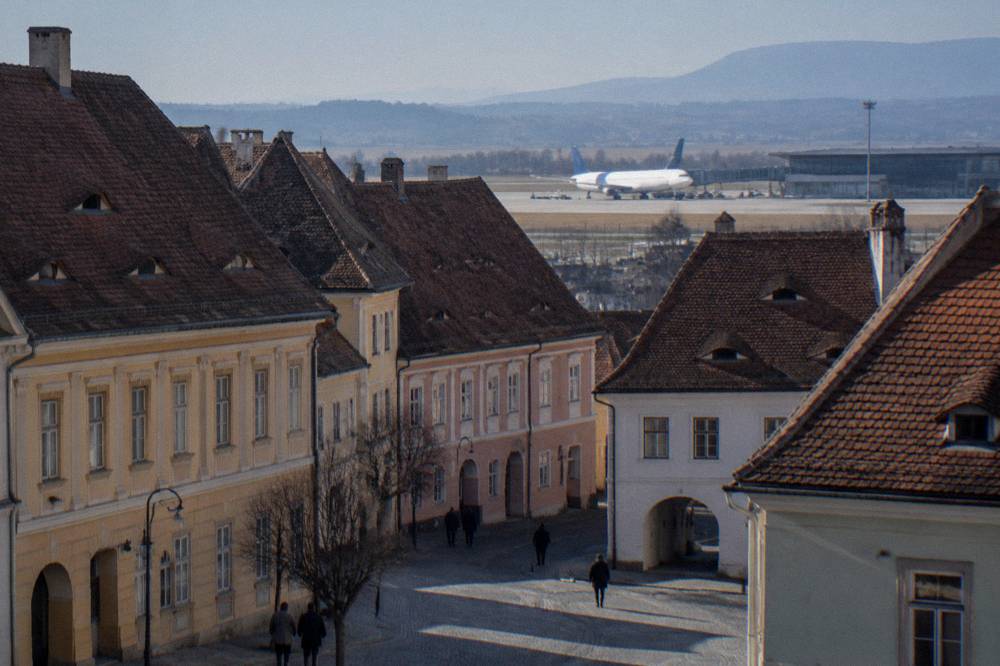 Small regional airport terminal with a plane at the gate under a clear sky