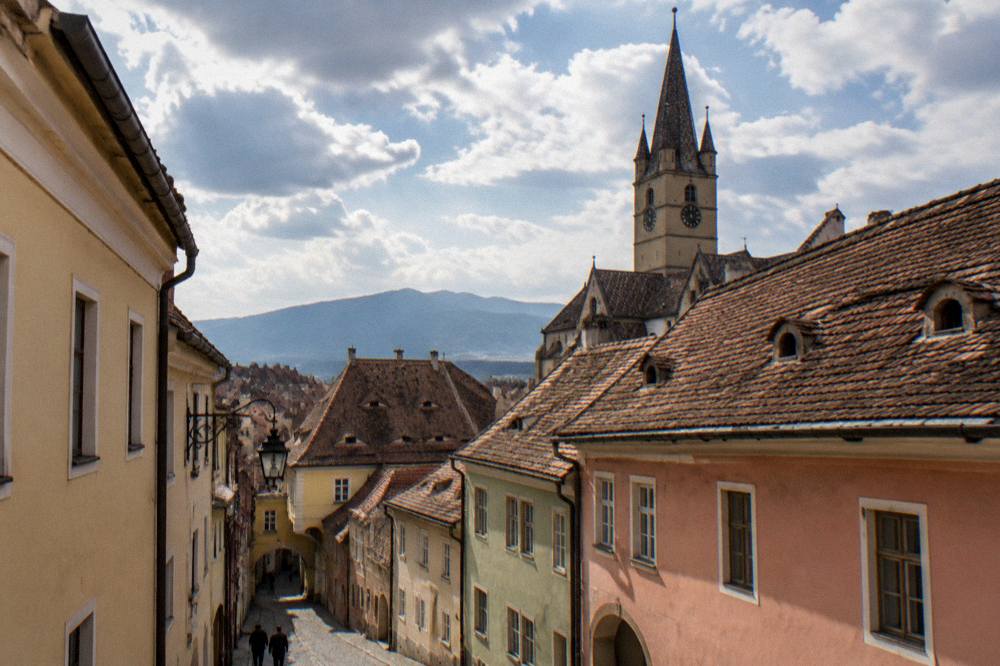 Rooftops of a Transylvanian old town with the Carpathian mountains faint on the horizon