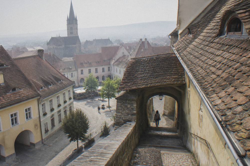 A narrow covered stone staircase passage connecting two levels of an old town