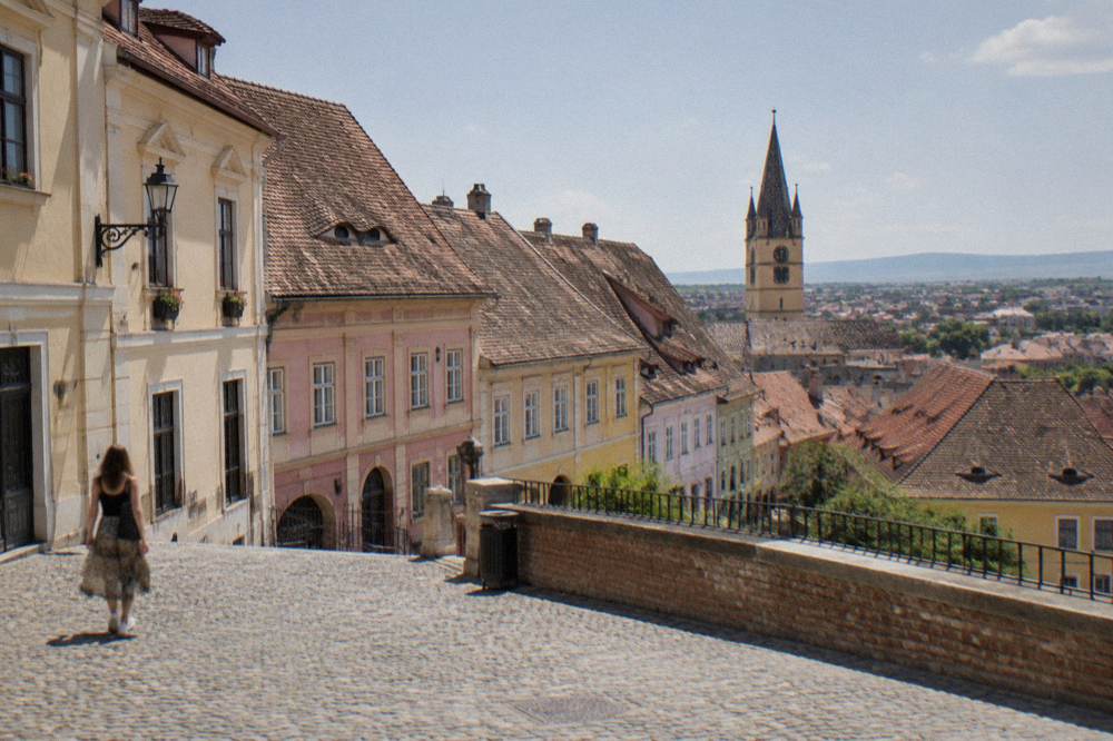 Rooftops with eye-shaped dormer windows descending toward the lower town of Sibiu