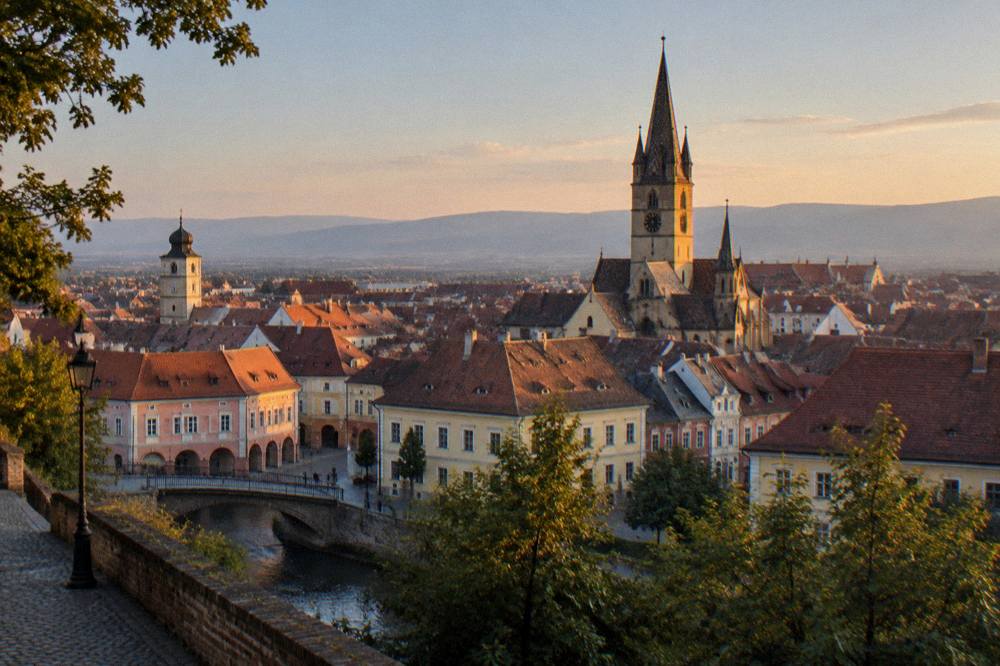 Evening light on the rooftops and church spires of Sibiu seen from a distance