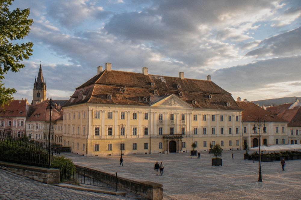 Rooftops of an old Transylvanian town at golden hour seen from a hillside path