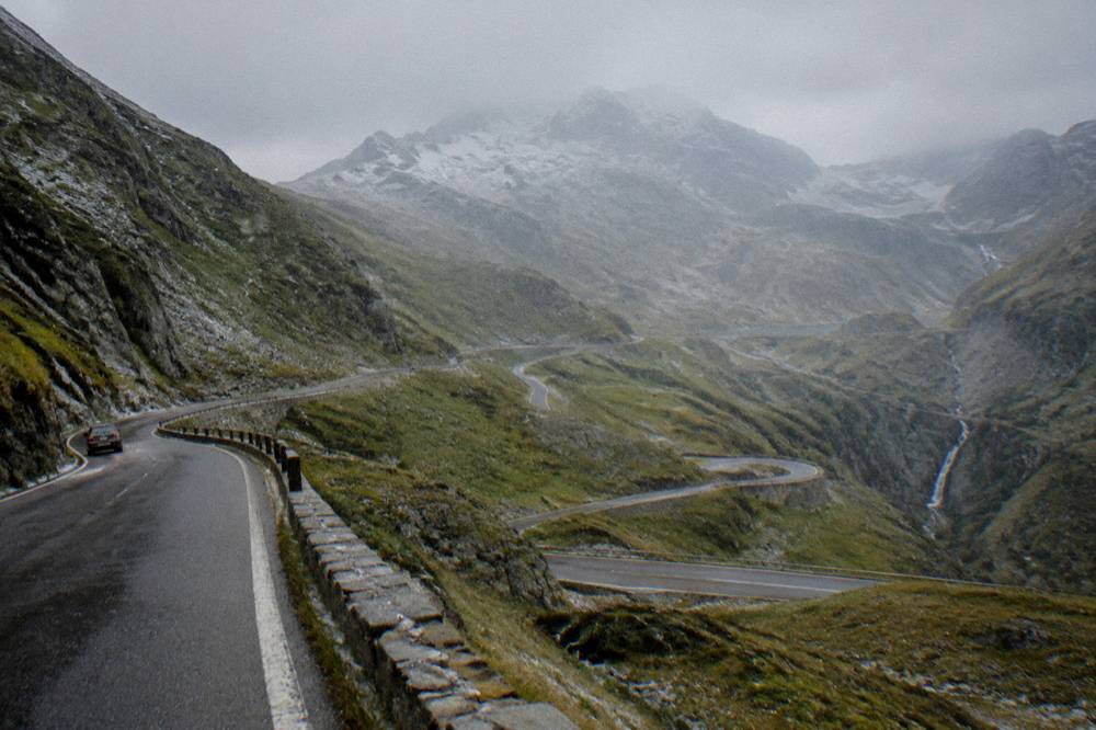 Alpine road switchbacks climbing the Transfăgărășan towards rocky peaks and Bâlea Lake
