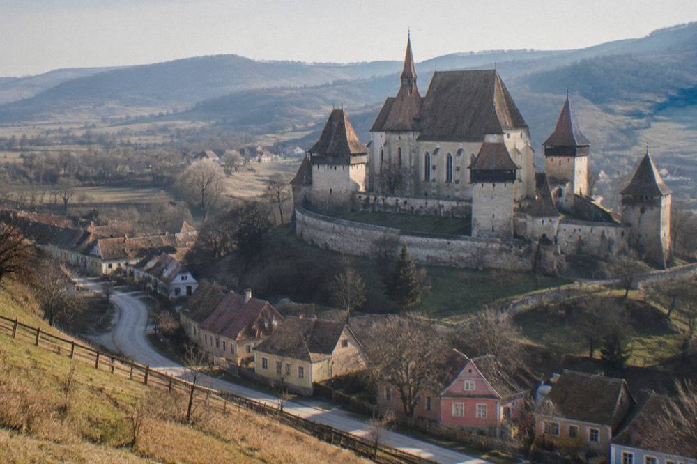 Winding country road through hay meadows between Saxon villages in Transylvania