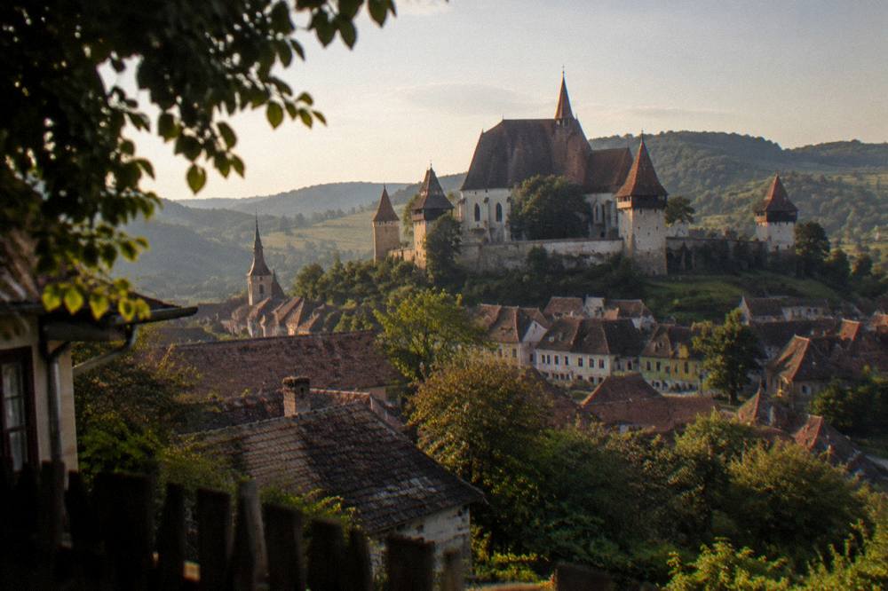 Panorama of coloured houses and church spires seen from a hill above a Transylvanian town
