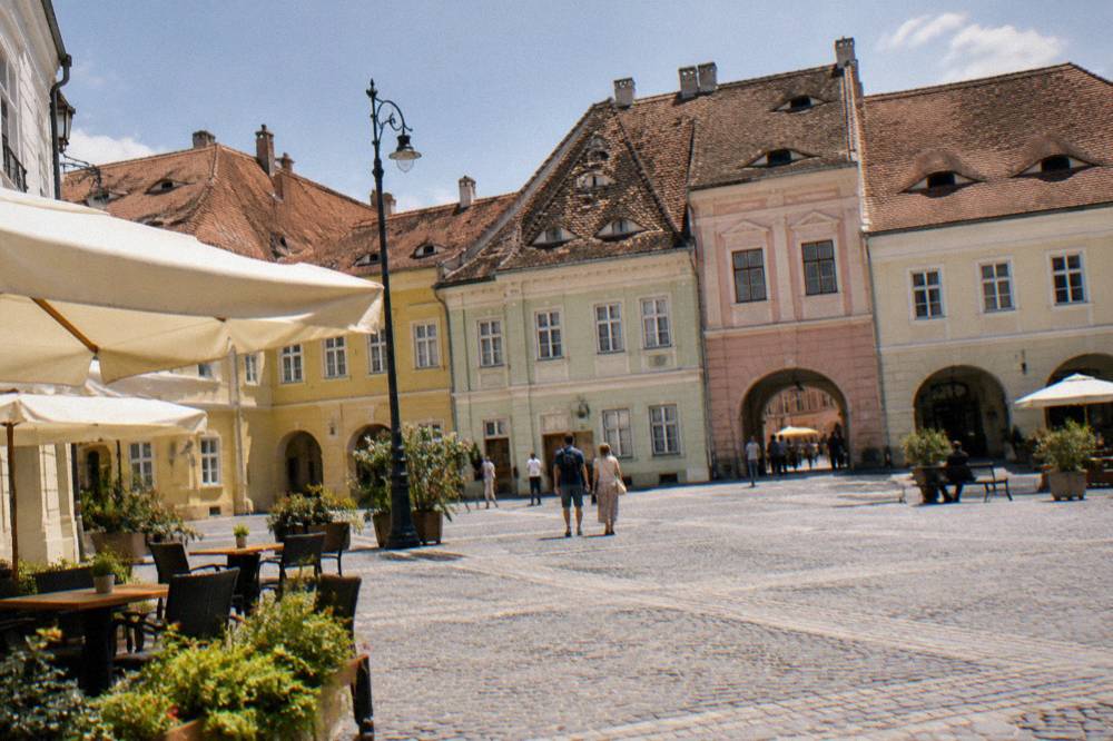 Pastel facades with small attic windows lining a square in Sibiu old town