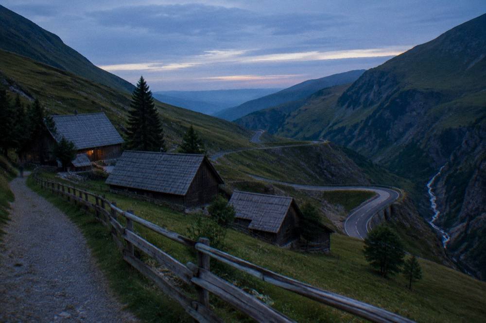 Wooden farmhouses and barns of an open-air folk museum beside a forest path