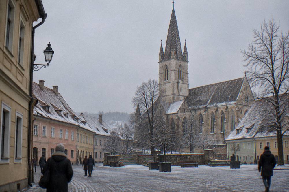 A fortified Saxon church on a hill above a snow-dusted Transylvanian village
