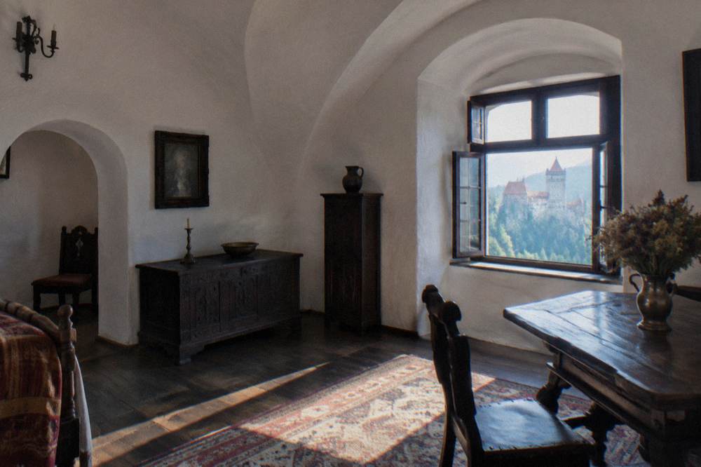 A whitewashed room with arched ceilings and period furniture inside Bran Castle