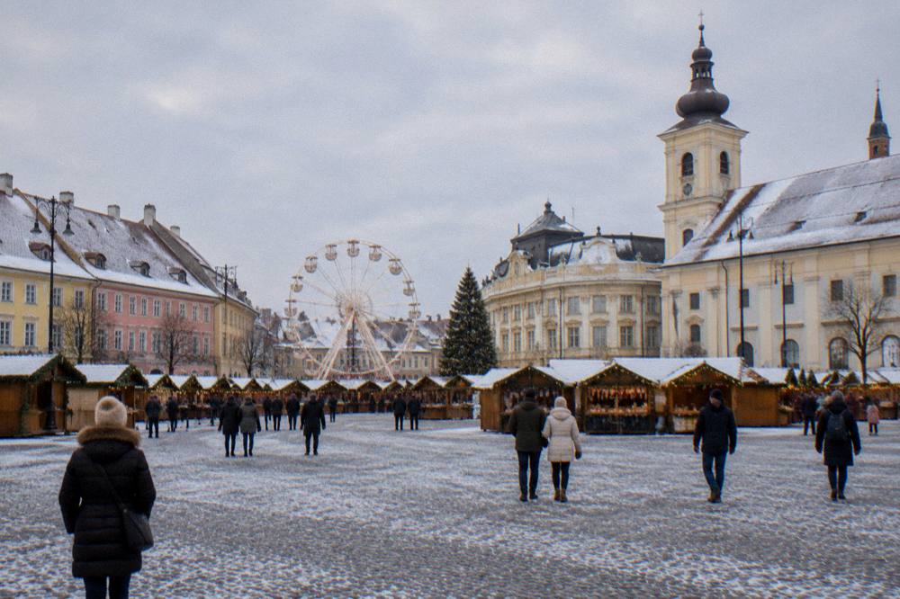 Sibiu's Great Square set up for the Christmas market with wooden stalls and a ferris wheel