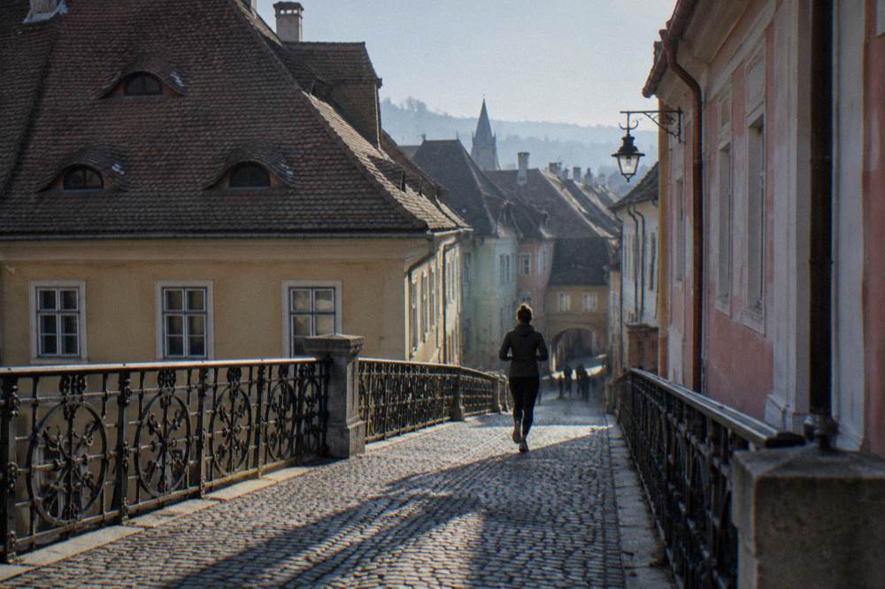 An iron footbridge crossing a lane between old houses in Sibiu's historic centre