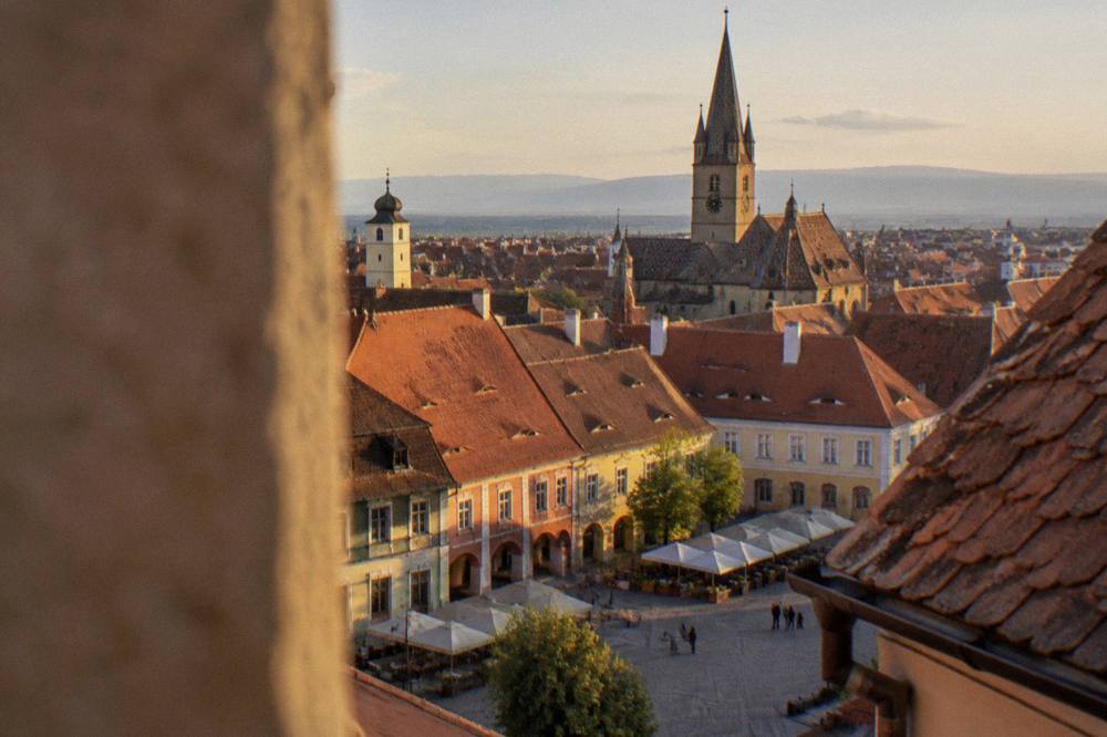 Warm evening light on the rooftops and church spires of Sibiu's old town seen from above