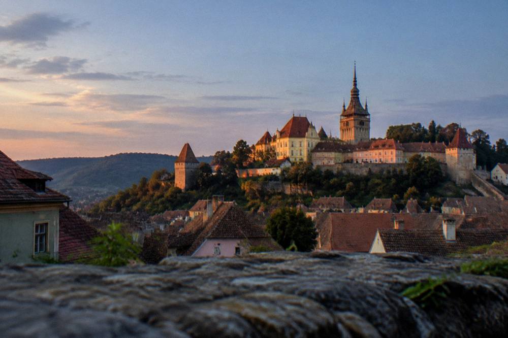 Sunset light on the roofs and towers of the Sighișoara citadel seen from a distance